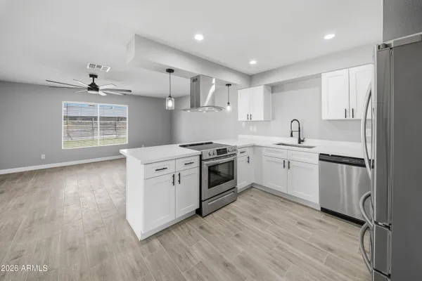 a kitchen with white cabinets stainless steel appliances and sink