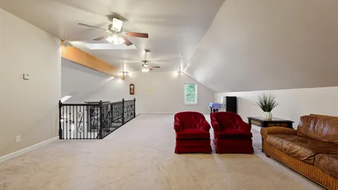 a view of a livingroom with a ceiling fan & entryway
