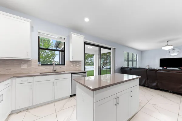 a kitchen with granite countertop a sink and white cabinets