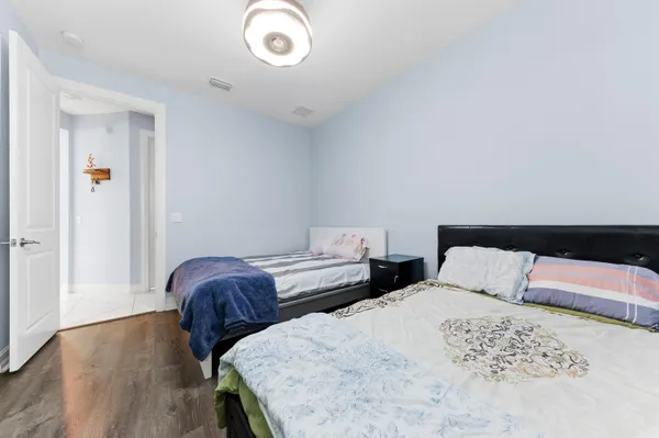 a bedroom with two beds and wooden floor
