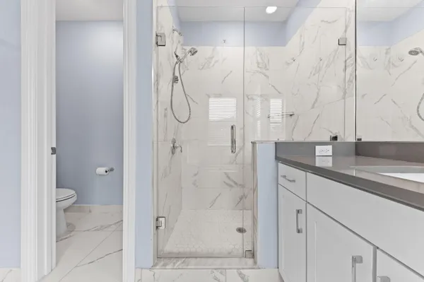 a bathroom with a granite countertop shower sink and mirror