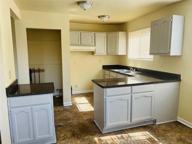 a kitchen with granite countertop a sink and cabinets