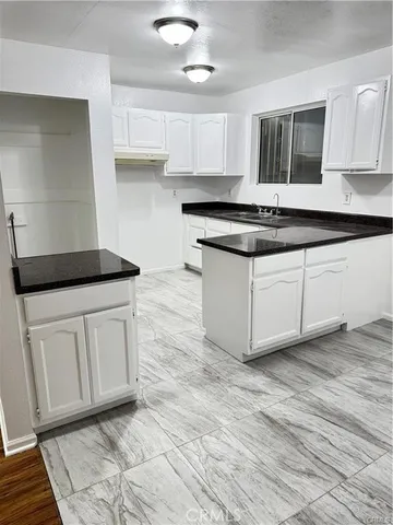 a kitchen with granite countertop a sink and a stove