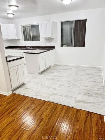 a kitchen with stainless steel appliances granite countertop a stove a sink and a white wooden cabinets
