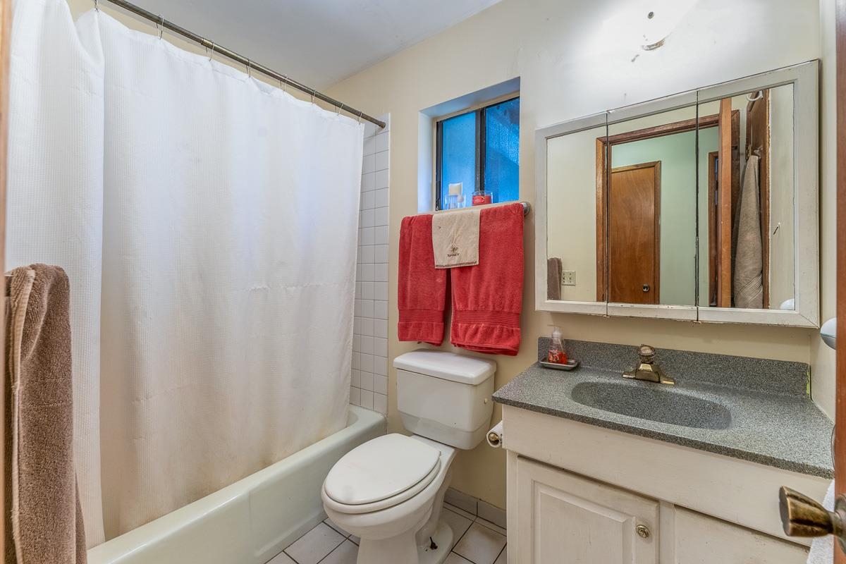 899 Kokomo Road Haiku, HI 96708 - Photo 19 of 26 a bathroom with a granite countertop sink toilet and mirror
