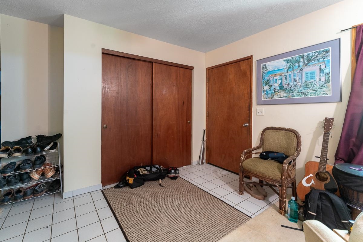 899 Kokomo Road Haiku, HI 96708 - Photo 4 of 26 a room with furniture a rug and a window
