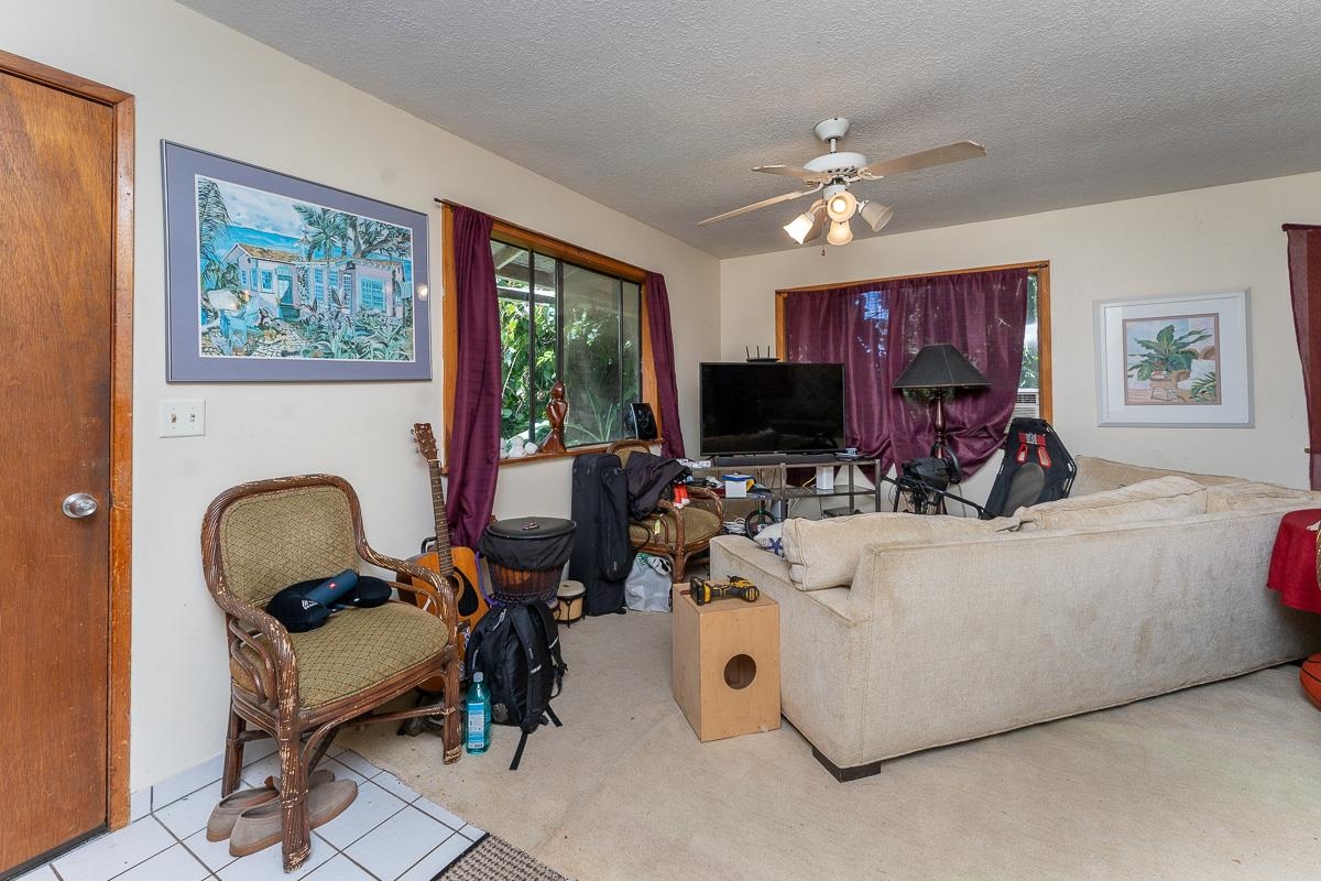 899 Kokomo Road Haiku, HI 96708 - Photo 5 of 26 a living room with furniture and a flat screen tv