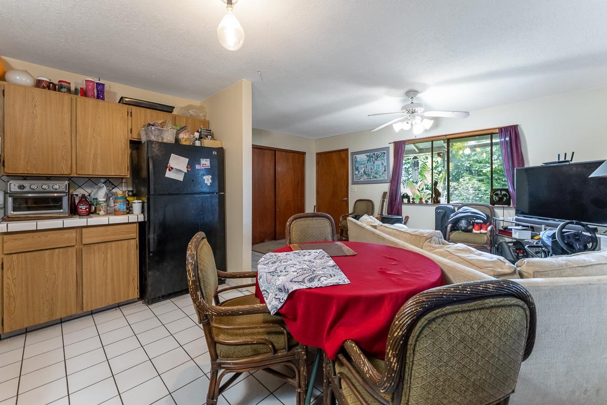 899 Kokomo Road Haiku, HI 96708 - Photo 6 of 26 a bedroom with a bed a table chair and a refrigerator