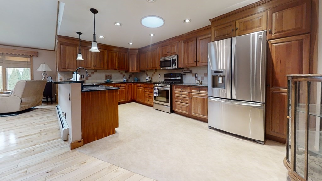 51 Miriam Road Waltham, MA 02451 - Photo 4 of 17 a kitchen with stainless steel appliances granite countertop a refrigerator a stove top oven a sink dishwasher and a refrigerator with wooden floor