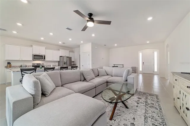 a living room with furniture white walls and a large window