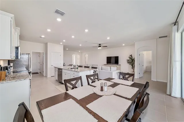 a large kitchen with stainless steel appliances granite countertop a sink stove and refrigerator