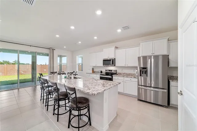 a kitchen with kitchen island a counter top space a sink stainless steel appliances and cabinets