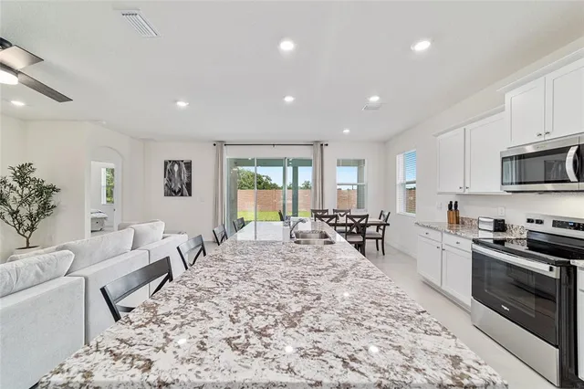 a kitchen with kitchen island sink and living room view
