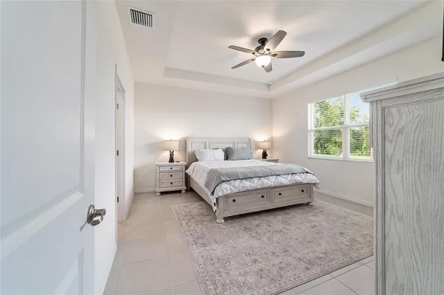 a bedroom with a bed and a flat tv screen on dresser