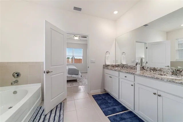 a bedroom with a bed and a chandelier fan