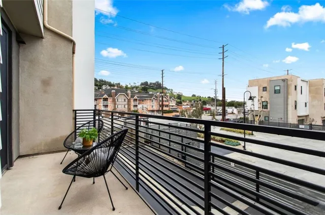 a view of a balcony with chairs and a potted plant