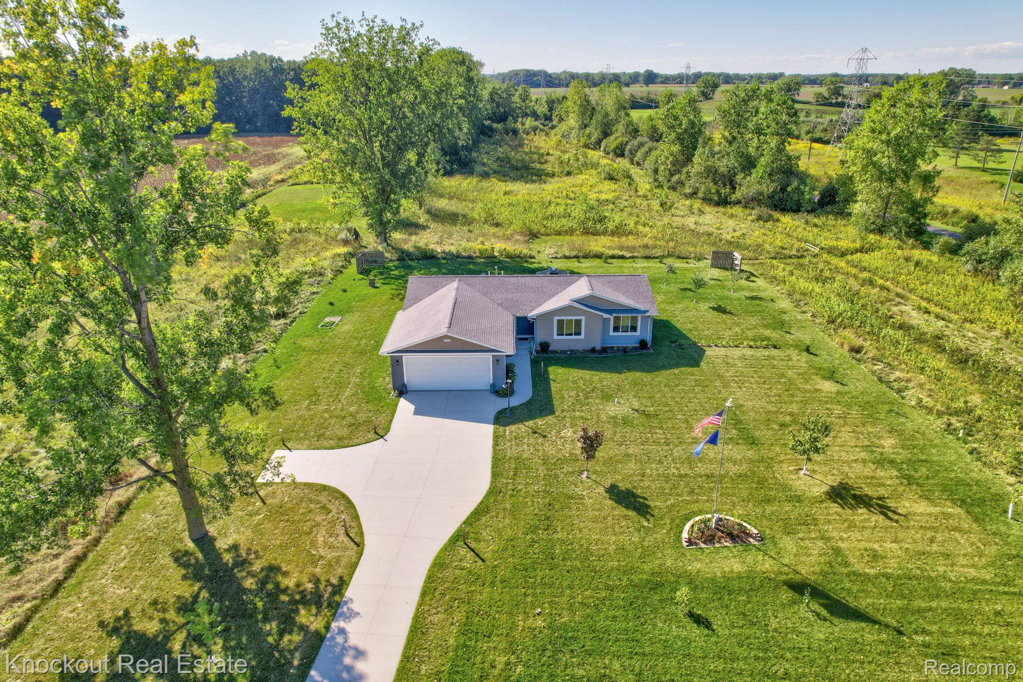 5727 Mackinaw Road Saginaw, MI 48604 - Photo 45 of 60 Single-story residence featuring a two-car garage, concrete driveway, and expansive green lawn