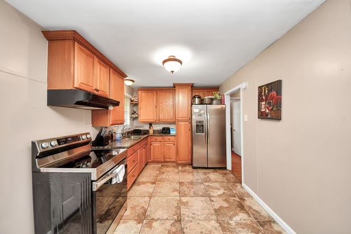 2914 Dragonwick Drive Houston, TX 77045 - Photo 12 of 37 a kitchen with stainless steel appliances a refrigerator a sink a stove and cabinets