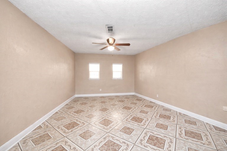 2914 Dragonwick Drive Houston, TX 77045 - Photo 25 of 37 an empty room with windows and ceiling fan
