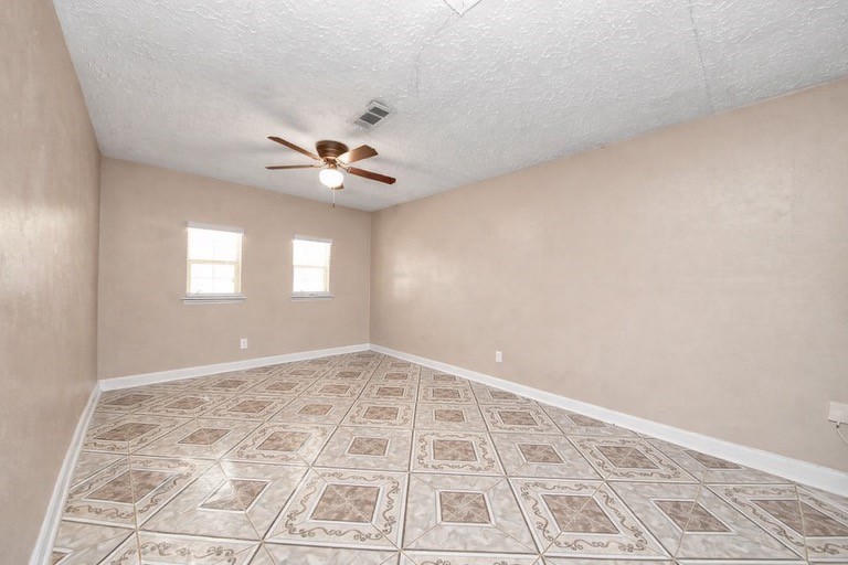 2914 Dragonwick Drive Houston, TX 77045 - Photo 26 of 37 an empty room with windows and ceiling fan