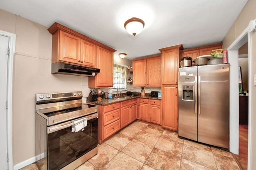 2914 Dragonwick Drive Houston, TX 77045 - Photo 7 of 37 a kitchen with granite countertop a refrigerator and a stove top oven