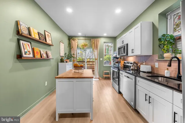 a kitchen with stainless steel appliances granite countertop a stove a sink and a refrigerator