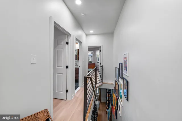 a view of a hallway with wooden floor and stairs