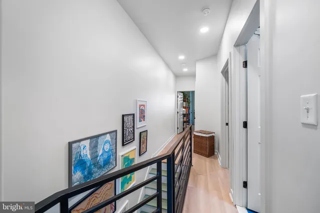 a view of a hallway with wooden floor and stairs