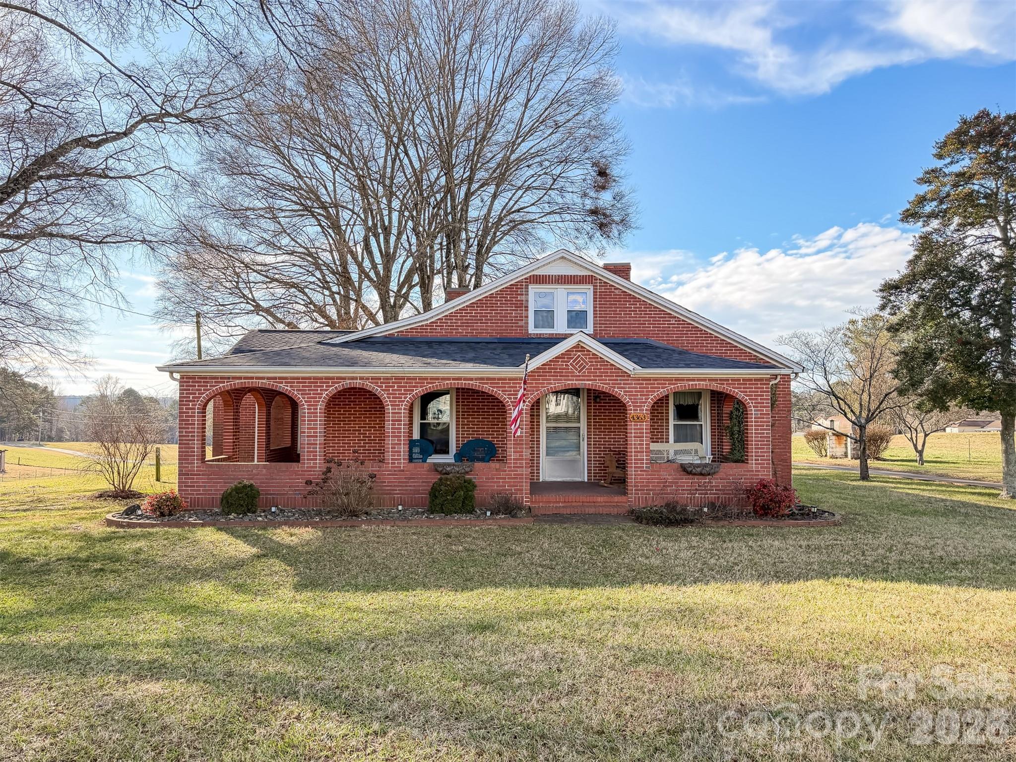 a front view of house with yard and trees in the background