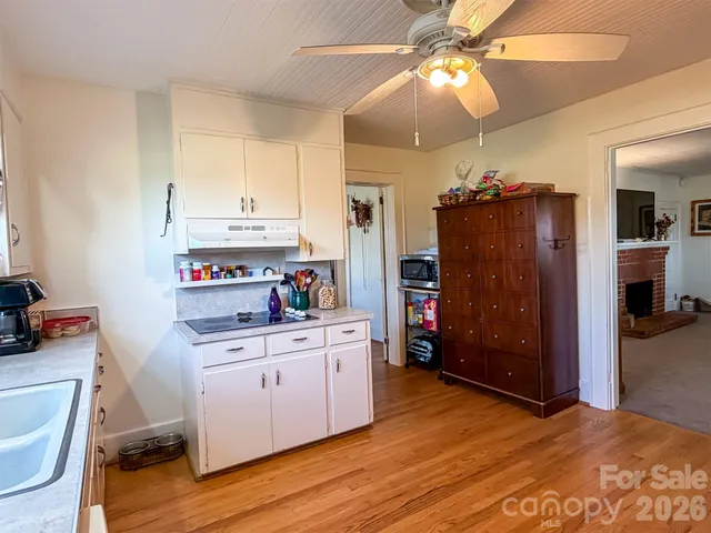 a kitchen that has a lot of cabinets in it and wooden floors