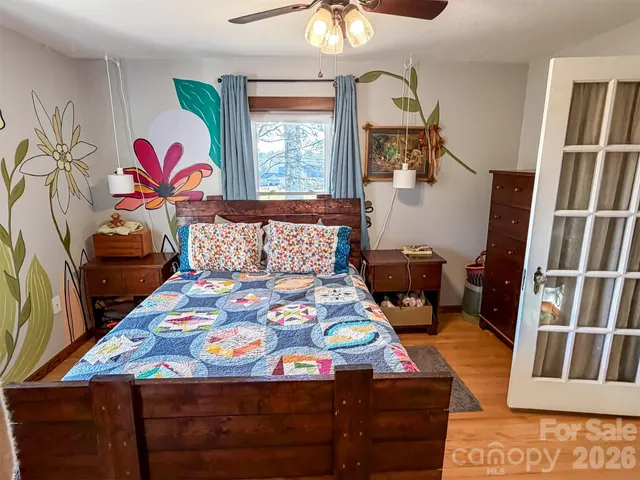 a bedroom with a bed and dresser with mirror