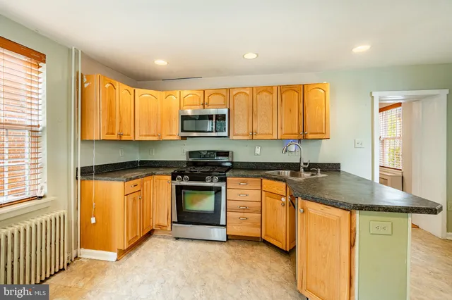 a kitchen with stainless steel appliances granite countertop a stove a sink and a refrigerator