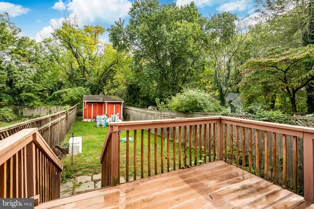 a balcony with wooden floor and trees in the back