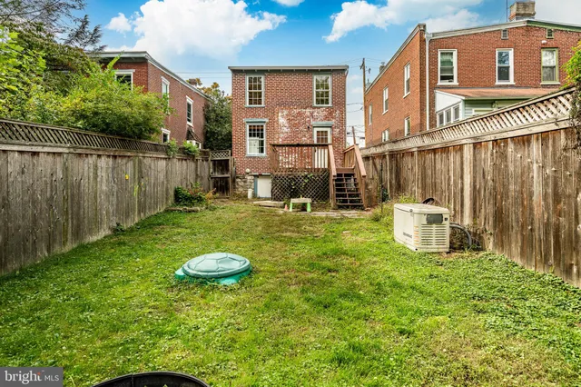 a view of a chair and table in backyard of the house