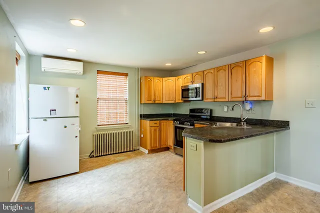 a kitchen with granite countertop cabinets stainless steel appliances and a window