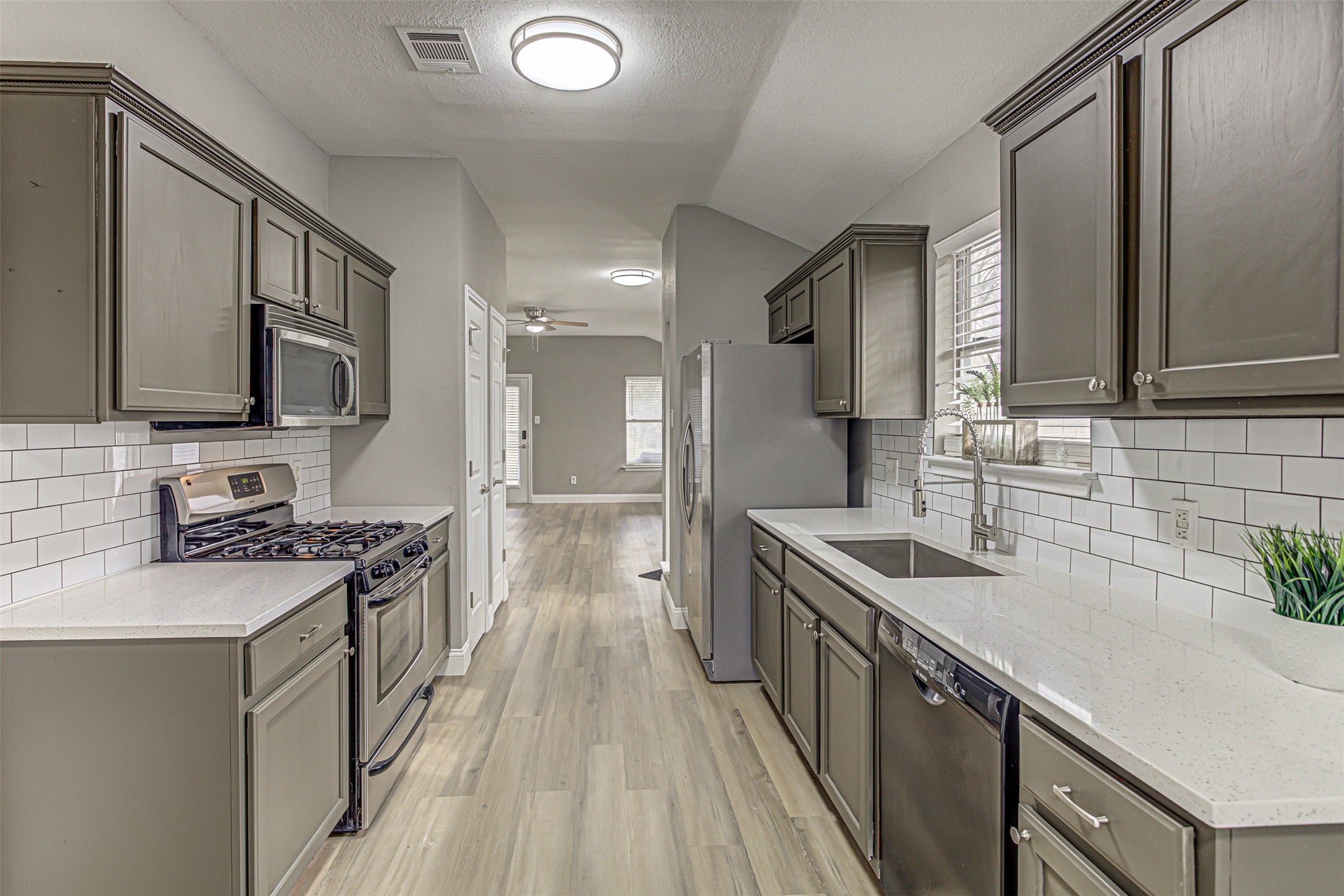 17838 Loch Linnhe Loop Pflugerville, TX 78660 - Photo 7 of 35 a kitchen with stainless steel appliances granite countertop a sink stove microwave and cabinets
