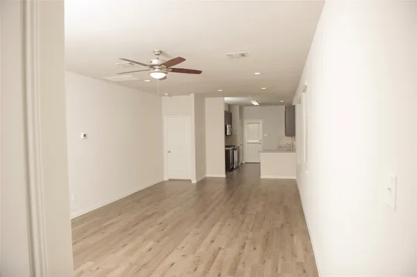 a view of a big room with wooden floor and a ceiling fan