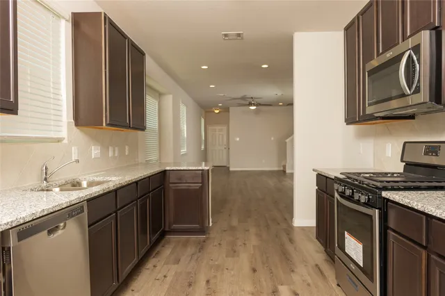 a kitchen with stainless steel appliances granite countertop a sink stove and cabinets