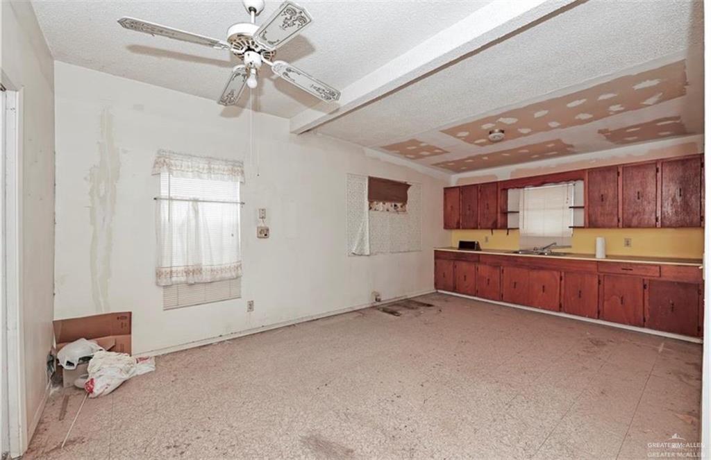 107 East Main Street Rio Grande City, TX 78582 - Photo 13 of 16 Kitchen with brown cabinets, ceiling fan, a textured ceiling, and a sink
