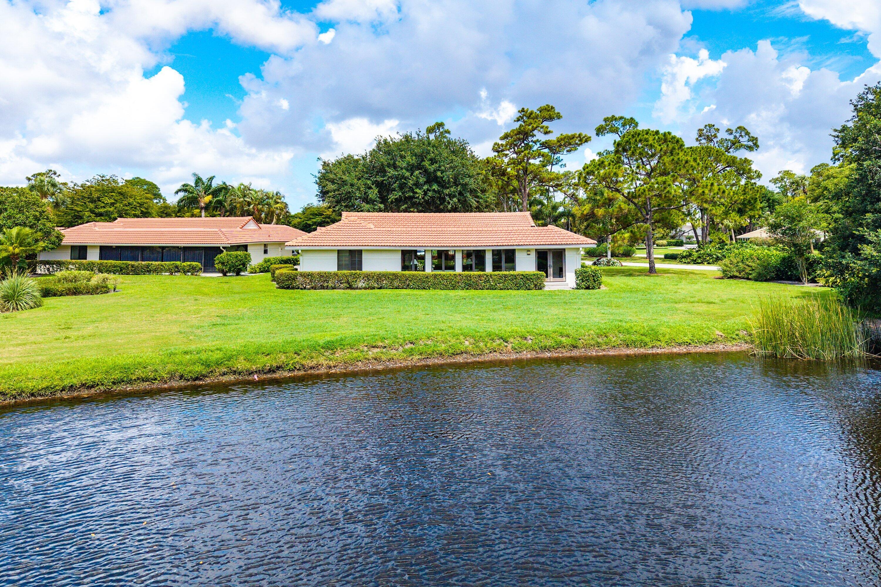 4365 Shell Drake Lane Boynton Beach, FL 33436 - Photo 36 of 56 a white house with a yard and lake view