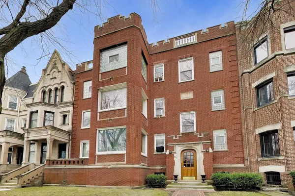 a front view of a residential apartment building with a yard