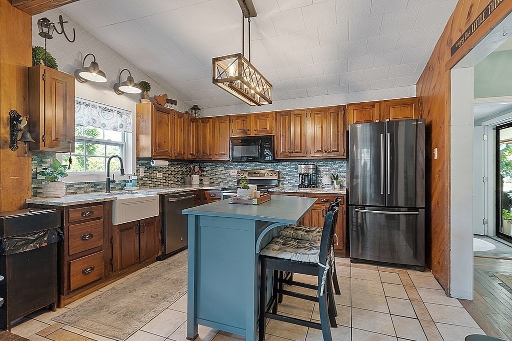 32 Ash Street Winchendon, MA 01475 - Photo 8 of 42 a kitchen with stainless steel appliances granite countertop a refrigerator a sink dishwasher a stove a dining table and chairs with wooden floor