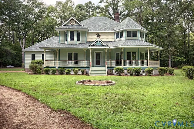 a front view of a house with a yard and potted plants