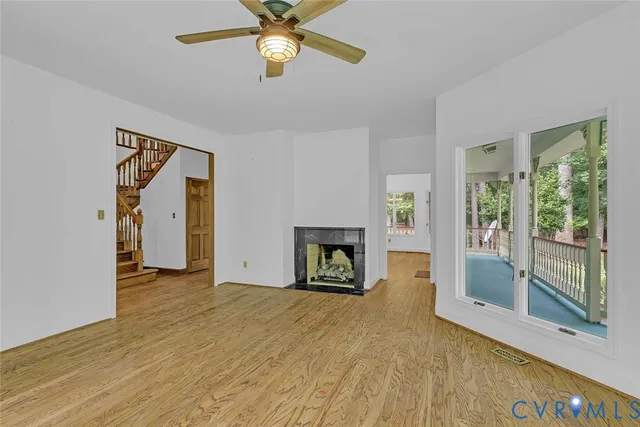 a view of an empty room with a fireplace and a window