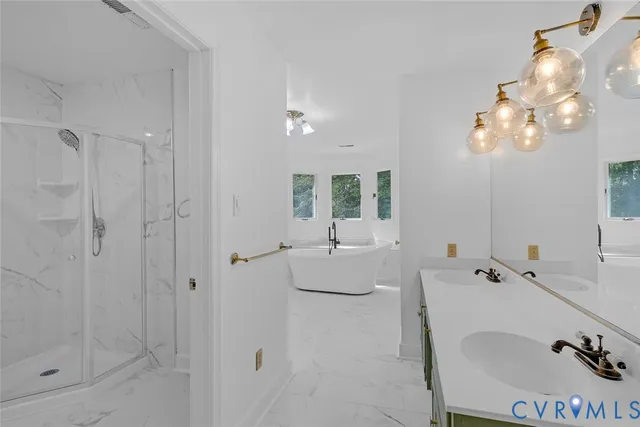 a bathroom with a tub a sink and mirror