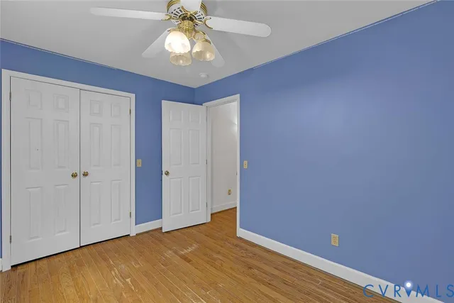 a view of an empty room with a chandelier fan