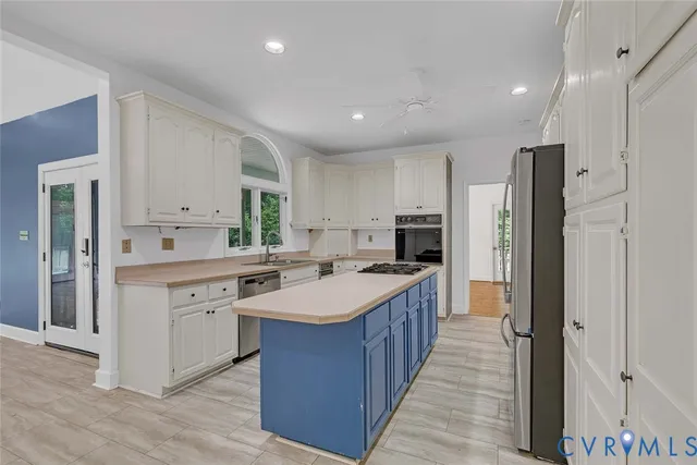 a large kitchen with stainless steel appliances a sink stove and refrigerator