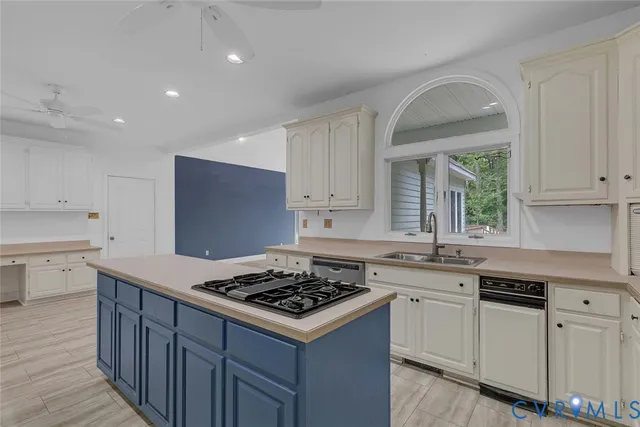 a kitchen with a stove a sink and wooden floor