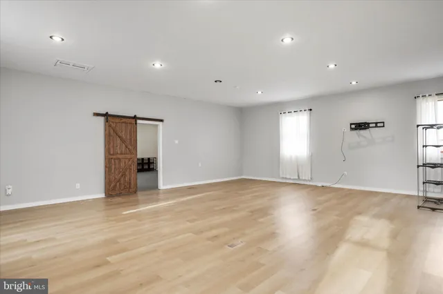 a view of an empty room with wooden floor