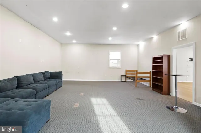 a living room with furniture and a ceiling fan
